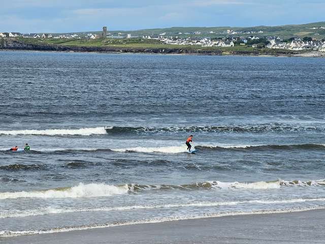 Beginner surfer riding a knee high wave in the shallows